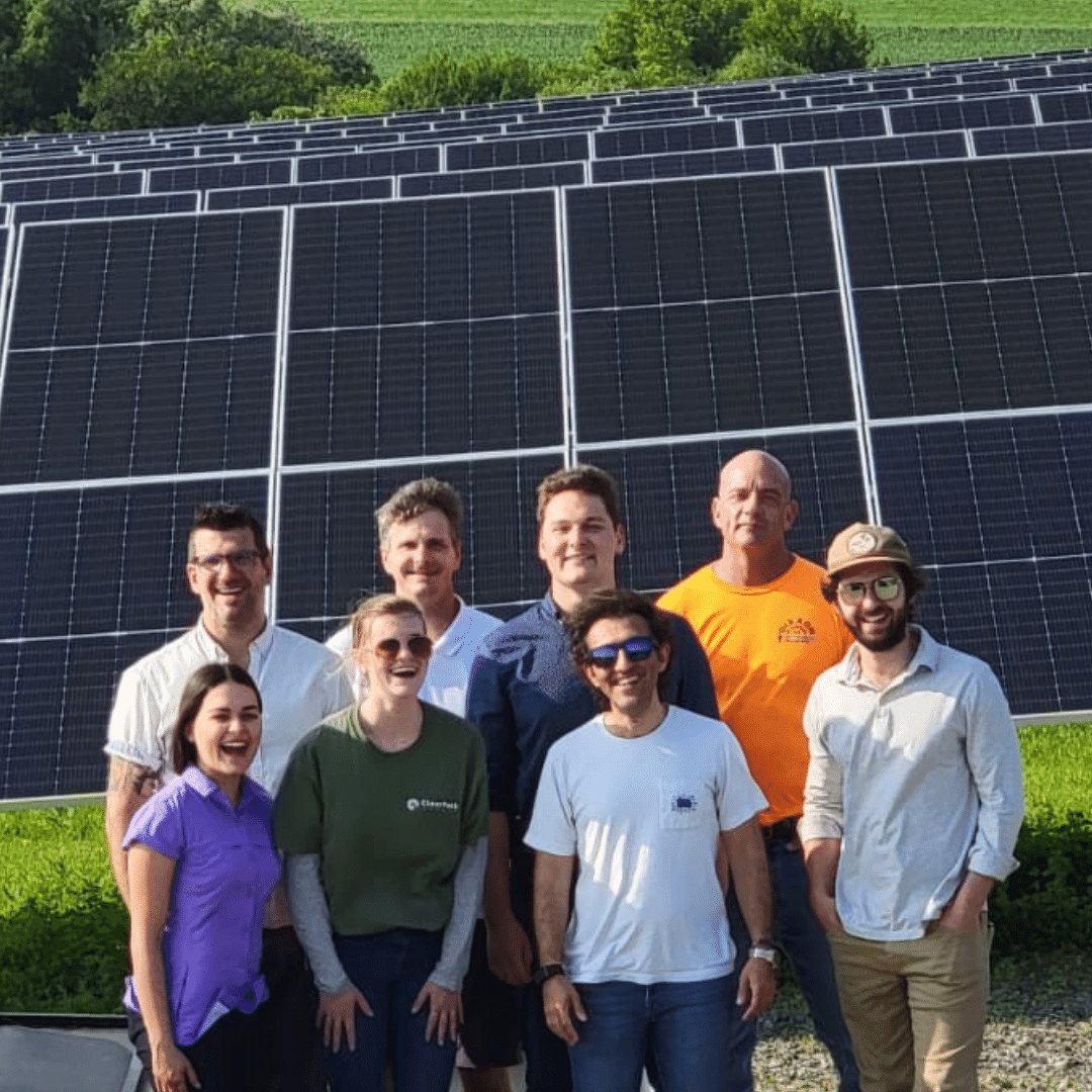 ClearPath Energy team in front of solar array on community solar farm
